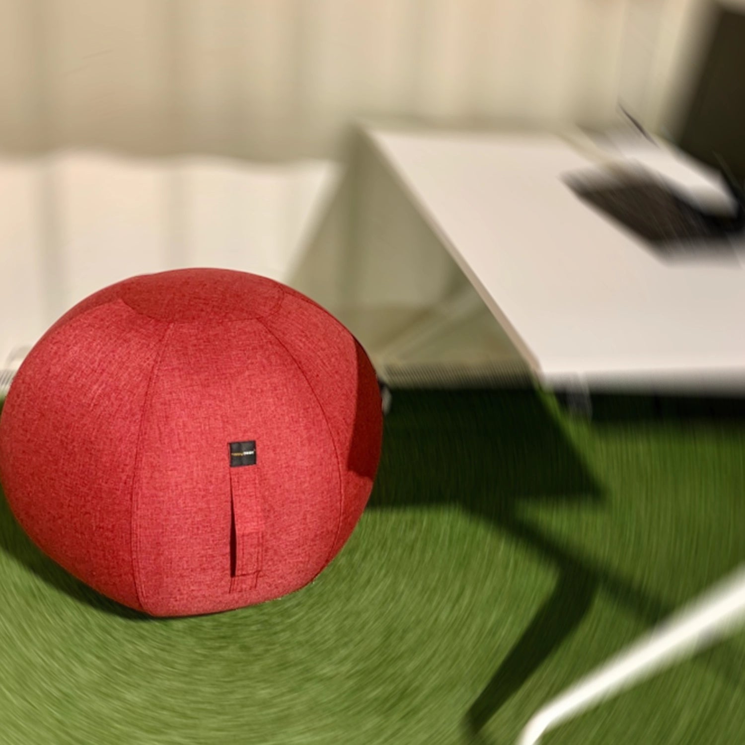 Ballon ergonomique rouge devant un bureau
